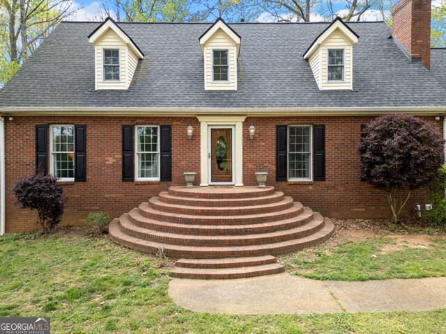 6695 Woodstock Rd, Acworth, GA 30102 - cape cod-style house featuring a shingled roof, a chimney, and brick siding
