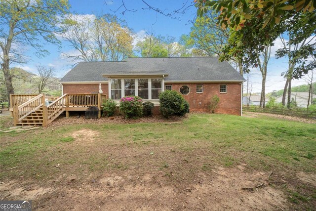 6695 Woodstock Rd, Acworth, GA 30102 - back of house featuring brick siding, a sunroom, a wooden deck, and a yard
