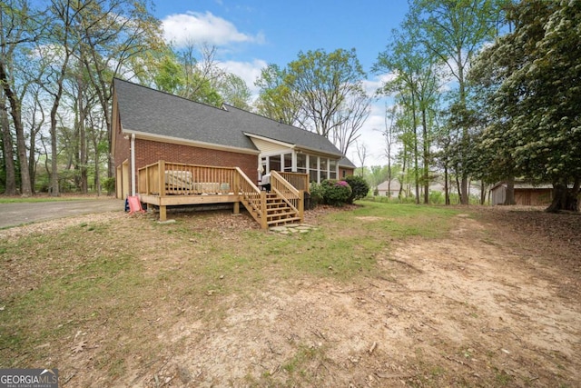 6695 Woodstock Rd, Acworth, GA 30102 - exterior space featuring driveway, a wooden deck, brick siding, a shingled roof, and a sunroom
