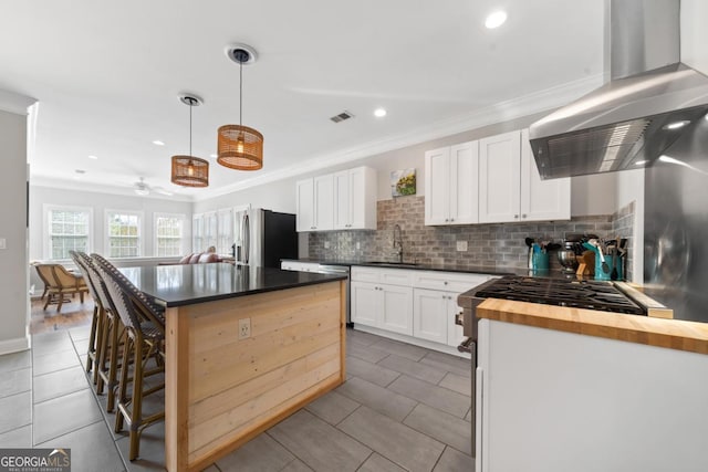 1081 Katherine Ln, Greensboro, GA 30642 - kitchen with stainless steel appliances, visible vents, ornamental molding, and wall chimney range hood