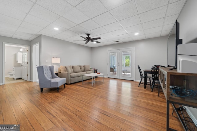 1081 Katherine Ln, Greensboro, GA 30642 - living room with french doors, a ceiling fan, a paneled ceiling, and light wood finished floors