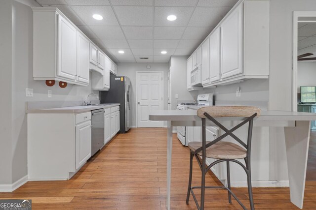 1081 Katherine Ln, Greensboro, GA 30642 - kitchen featuring white cabinets, recessed lighting, and white appliances