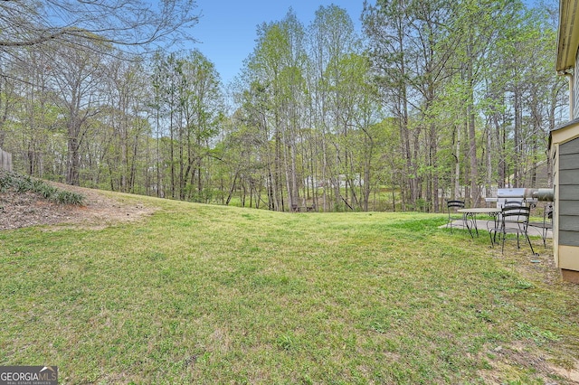 view of yard featuring a forest view