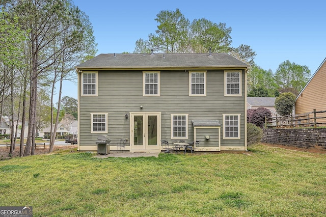 back of property with fence, french doors, a yard, and a patio