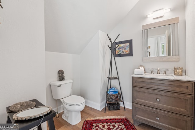 8012 Beachwood Dr, Murrayville, GA 30564 - bathroom featuring vanity, vaulted ceiling, toilet, wood finished floors, and baseboards