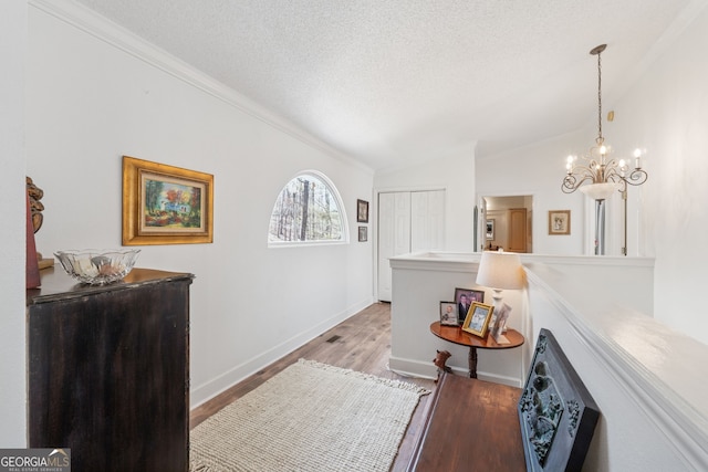 8012 Beachwood Dr, Murrayville, GA 30564 - hall featuring baseboards, vaulted ceiling, a chandelier, a textured ceiling, and light wood-style floors