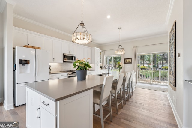 8012 Beachwood Dr, Murrayville, GA 30564 - kitchen with a sink, an island with sink, crown molding, stainless steel appliances, and decorative backsplash