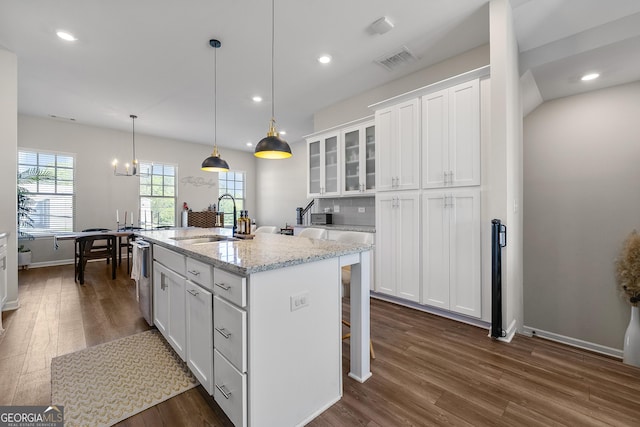 6023 Skellig St, Norcross, GA 30071 - kitchen with dark wood-style flooring, white cabinetry, glass insert cabinets, a kitchen bar, and a kitchen island with sink