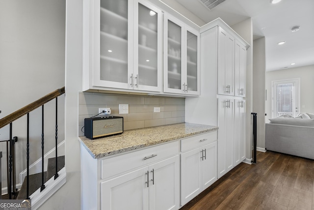 6023 Skellig St, Norcross, GA 30071 - kitchen featuring glass insert cabinets, white cabinetry, decorative backsplash, dark wood finished floors, and light stone countertops
