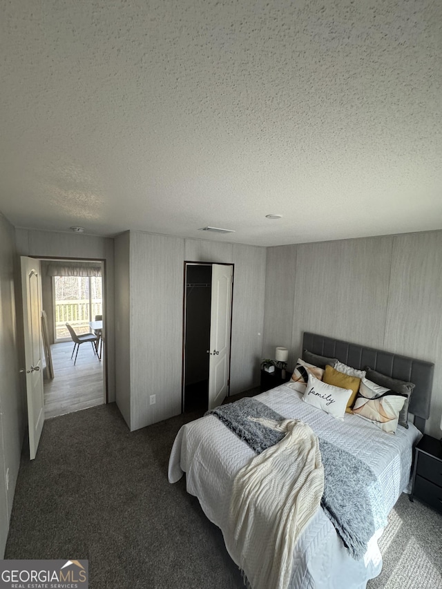 carpeted bedroom with visible vents, a textured ceiling, crown molding, and wooden walls