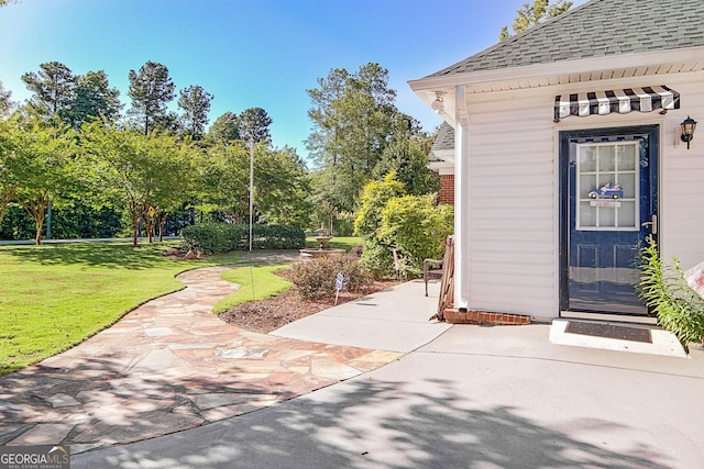 494 Thrash Rd, Lagrange, GA 30241 - view of exterior entry with roof with shingles, a lawn, and view of scattered trees