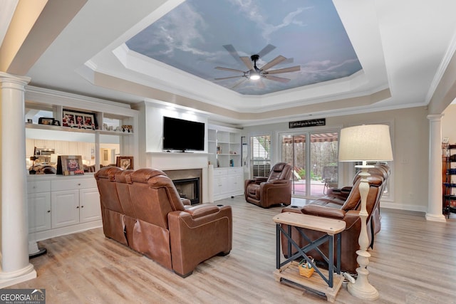 494 Thrash Rd, Lagrange, GA 30241 - living room with decorative columns, a tray ceiling, a ceiling fan, a fireplace, and light wood-type flooring