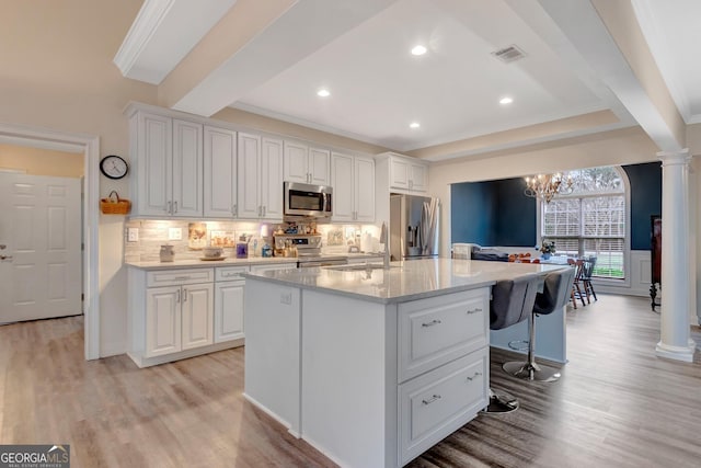494 Thrash Rd, Lagrange, GA 30241 - kitchen featuring stainless steel appliances, ornate columns, light wood finished floors, white cabinets, and decorative backsplash