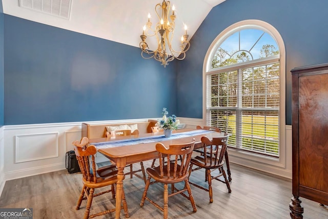 494 Thrash Rd, Lagrange, GA 30241 - dining space with healthy amount of natural light, a wainscoted wall, vaulted ceiling, a chandelier, and wood finished floors