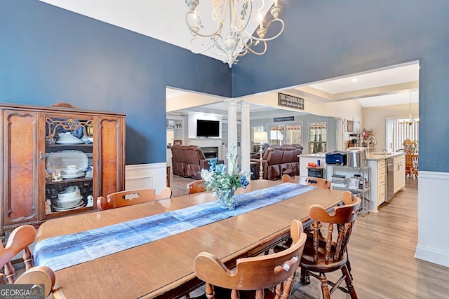 494 Thrash Rd, Lagrange, GA 30241 - dining room featuring a chandelier, ornate columns, light wood-style floors, baseboards, and wainscoting
