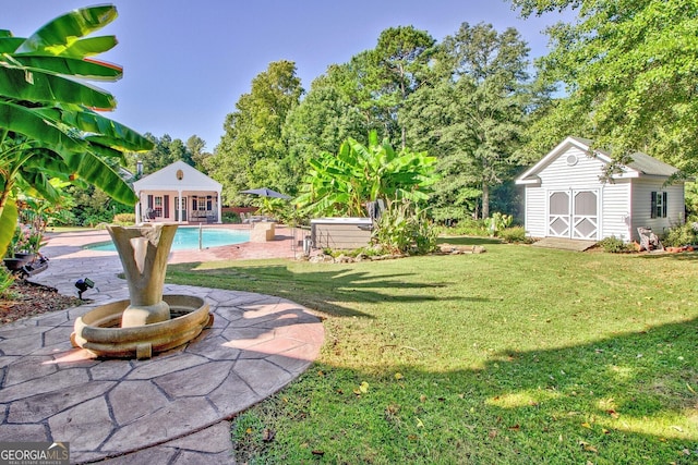 494 Thrash Rd, Lagrange, GA 30241 - view of grassy yard featuring an outbuilding, a patio area, an outdoor pool, an exterior structure, and view of wooded area