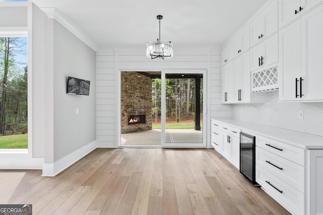 2107 E Maddox Rd, Buford, GA 30519 - kitchen with a chandelier, wine cooler, a healthy amount of sunlight, and light wood-type flooring