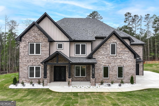 2107 E Maddox Rd, Buford, GA 30519 - view of front of home with board and batten siding, roof with shingles, a front yard, brick siding, and french doors