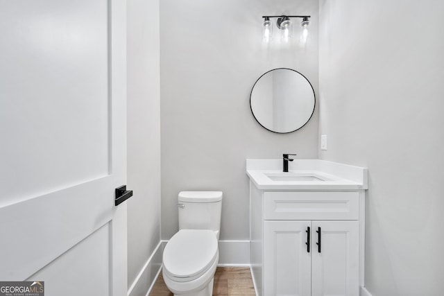 2107 E Maddox Rd, Buford, GA 30519 - bathroom featuring vanity, baseboards, toilet, and wood finished floors