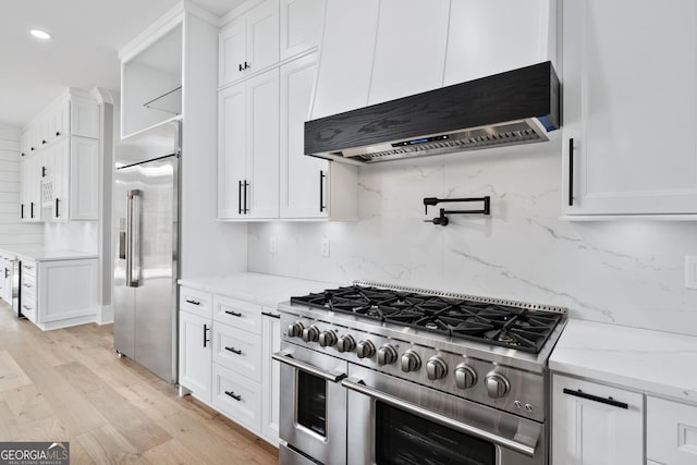 2107 E Maddox Rd, Buford, GA 30519 - kitchen featuring high quality appliances, ventilation hood, recessed lighting, white cabinets, and light wood-style flooring