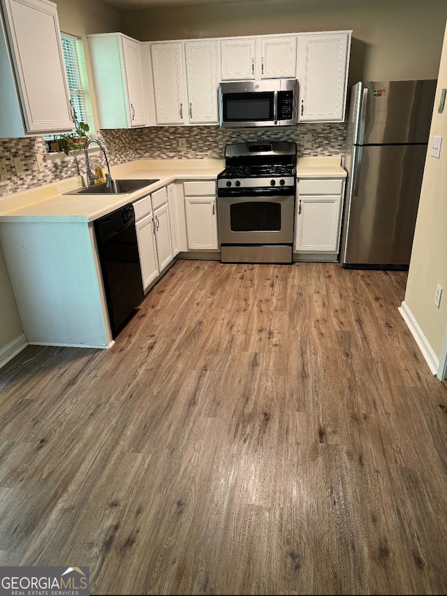 kitchen featuring white cabinetry, a sink, dark wood finished floors, and stainless steel appliances