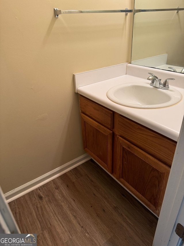 bathroom featuring vanity, baseboards, and wood finished floors