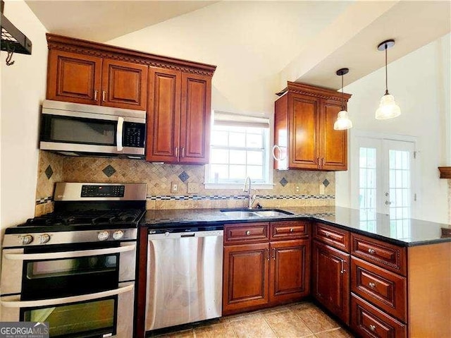 645 Crossbridge Aly, Johns Creek, GA 30022 - kitchen with a peninsula, decorative backsplash, stainless steel appliances, a sink, and hanging light fixtures