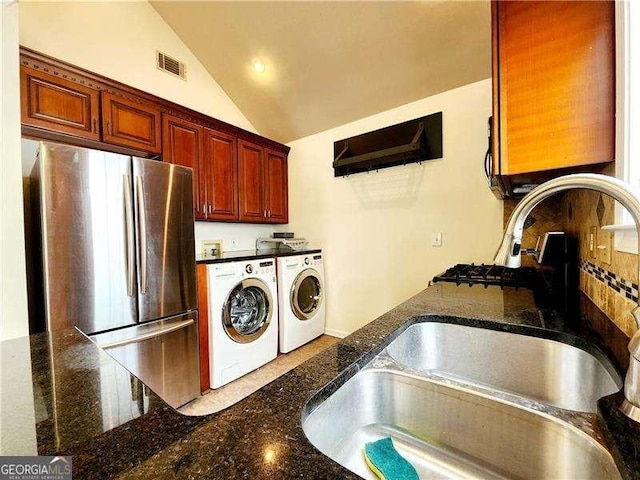 645 Crossbridge Aly, Johns Creek, GA 30022 - kitchen with separate washer and dryer, a sink, freestanding refrigerator, dark stone counters, and vaulted ceiling