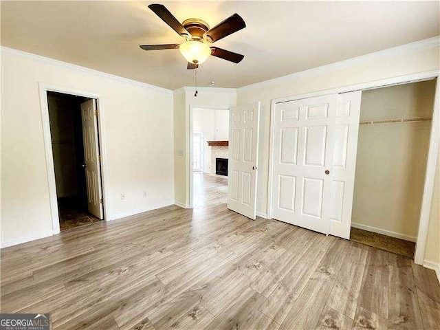 645 Crossbridge Aly, Johns Creek, GA 30022 - unfurnished bedroom with a closet, baseboards, a fireplace, crown molding, and wood finished floors