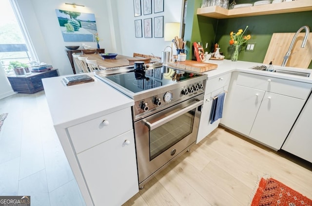 587 Virginia Ave NE Unit 314, Atlanta, GA 30306 - kitchen featuring stainless steel stove, white cabinetry, a peninsula, open shelves, and light countertops