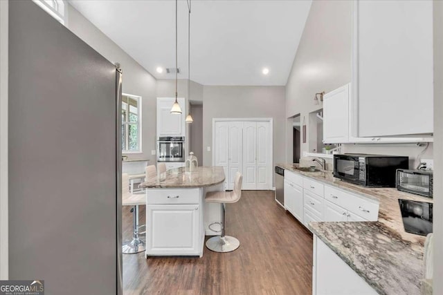 3800 Macland Rd, Hiram, GA 30141 - kitchen featuring stainless steel appliances, white cabinets, dark wood-style floors, a kitchen breakfast bar, and light stone countertops