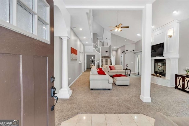 3800 Macland Rd, Hiram, GA 30141 - carpeted living area featuring high vaulted ceiling, ornate columns, ceiling fan, stairs, and a multi sided fireplace