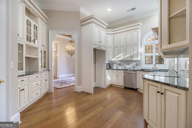 1418 Brighton Pl, Loganville, GA 30052 - kitchen with stainless steel dishwasher, a chandelier, ornamental molding, wood finished floors, and glass insert cabinets