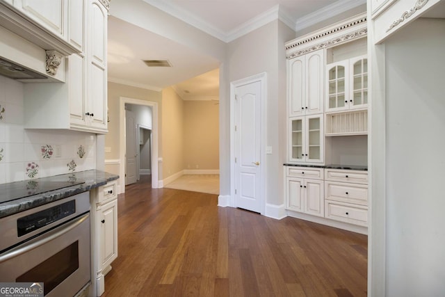 1418 Brighton Pl, Loganville, GA 30052 - kitchen featuring stainless steel oven, dark wood finished floors, crown molding, decorative backsplash, and baseboards