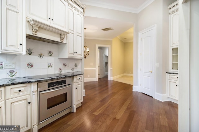 1418 Brighton Pl, Loganville, GA 30052 - kitchen with stainless steel oven, black electric stovetop, tasteful backsplash, baseboards, and crown molding