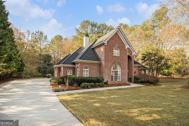 1418 Brighton Pl, Loganville, GA 30052 - view of side of property with brick siding, a yard, concrete driveway, a chimney, and a shingled roof