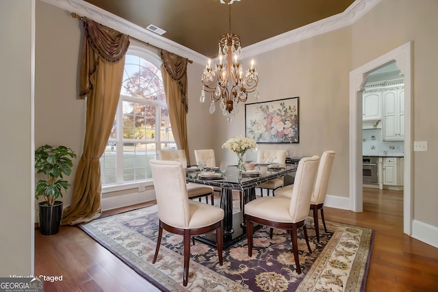 1418 Brighton Pl, Loganville, GA 30052 - dining area with a chandelier, wood finished floors, plenty of natural light, ornamental molding, and baseboards