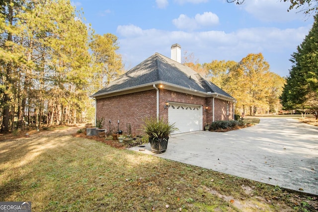 1418 Brighton Pl, Loganville, GA 30052 - view of home's exterior featuring brick siding, concrete driveway, a chimney, a garage, and a lawn