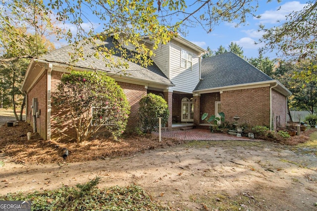 1418 Brighton Pl, Loganville, GA 30052 - view of front facade featuring brick siding, french doors, roof with shingles, and a patio