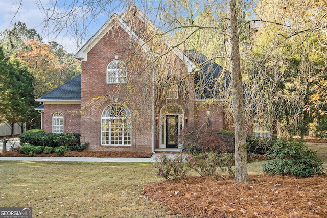 1418 Brighton Pl, Loganville, GA 30052 - view of front facade with brick siding, a front lawn, and a shingled roof