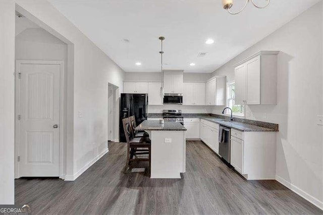 822 Pine Way, Dallas, GA 30157 - kitchen with stainless steel appliances, white cabinetry, dark wood-type flooring, a breakfast bar, and a kitchen island