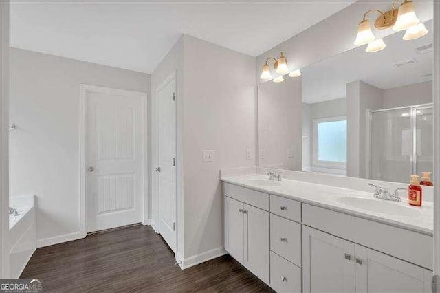 822 Pine Way, Dallas, GA 30157 - bathroom with double vanity, wood finished floors, a shower stall, a garden tub, and a chandelier