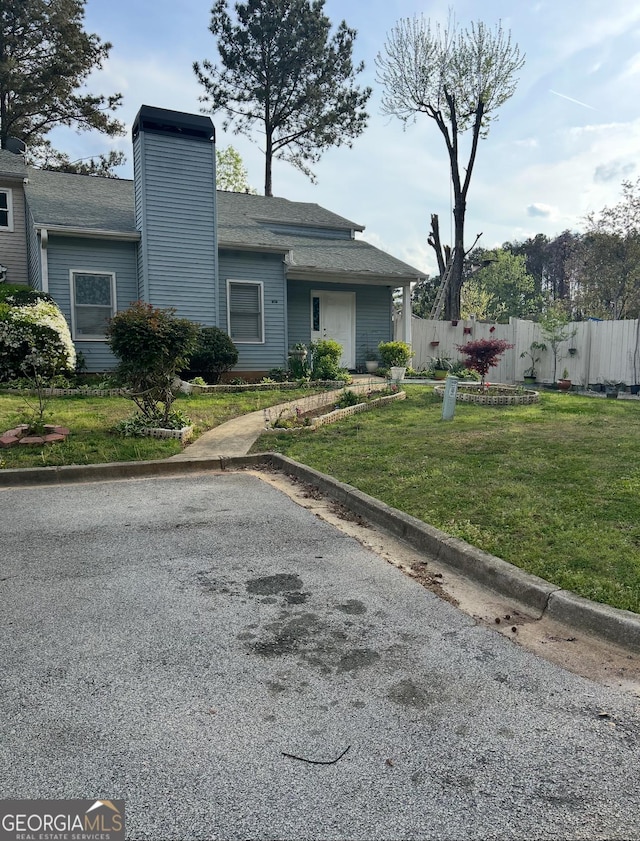 2220 Wellington Cir, Lithonia, GA 30058 - view of front of property featuring a chimney, a shingled roof, a front yard, and fence