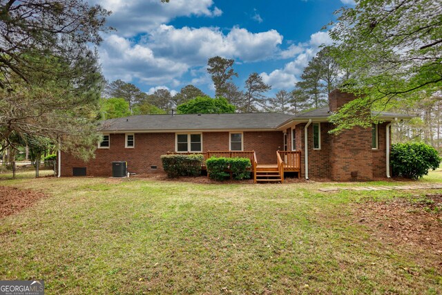 back of property featuring brick siding, a yard, central AC unit, and crawl space