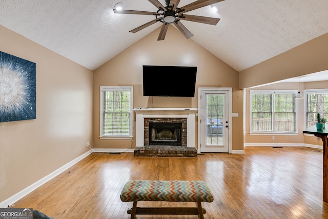 86 S Chattahoochee Dr, Hogansville, GA 30230 - living area with a fireplace with raised hearth, hardwood / wood-style floors, a ceiling fan, high vaulted ceiling, and a textured ceiling