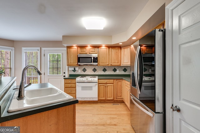 86 S Chattahoochee Dr, Hogansville, GA 30230 - kitchen featuring appliances with stainless steel finishes, light wood-style floors, tasteful backsplash, dark countertops, and recessed lighting