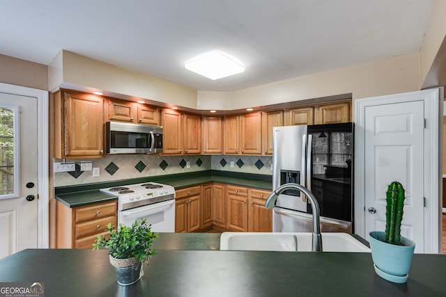 86 S Chattahoochee Dr, Hogansville, GA 30230 - kitchen featuring stainless steel appliances, dark countertops, backsplash, and brown cabinets