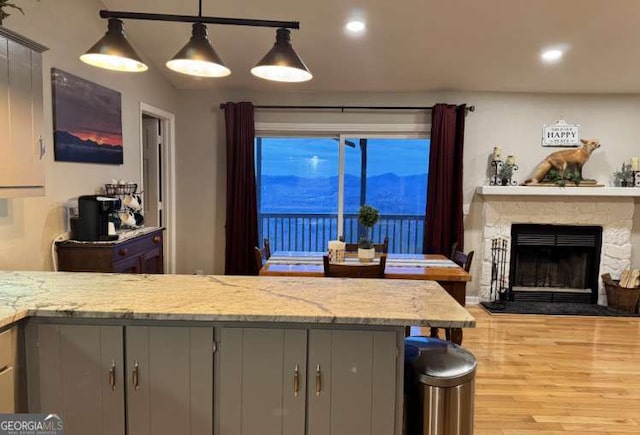 7 Lakeview Dr, Hayesville, NC 28904 - kitchen featuring a fireplace, light wood-style flooring, gray cabinetry, and light stone counters