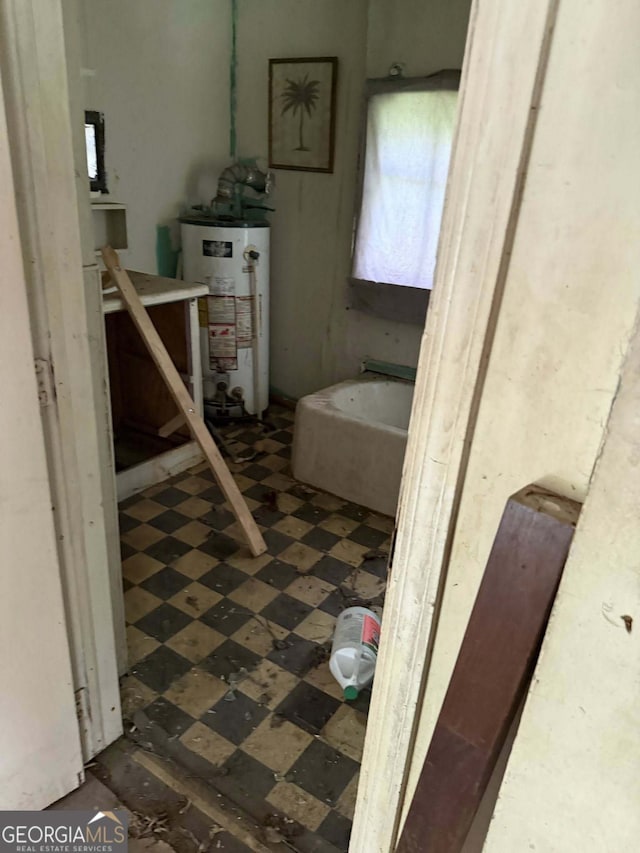 bathroom with a bath, tile patterned floors, and water heater
