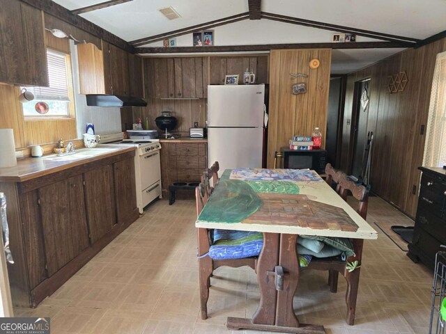 1467 Creek Rd, Hiawassee, GA 30546 - kitchen featuring gas range gas stove, freestanding refrigerator, wood walls, lofted ceiling, and light countertops